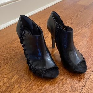 Black leather peep toe booties with crisscross sides. Size 7.5